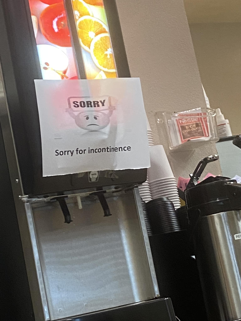 drink dispenser with a sign on it that says: sorry (a little unhappy face holding up that word) Sorry for incontinence