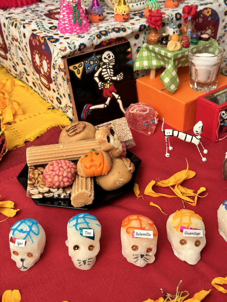 Sugar skulls, traditional Mexican sweets and a skeleton runner on the ofrenda