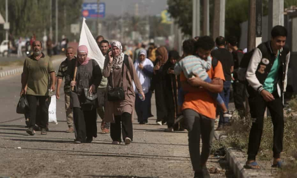 Palestinians carrying white flags flee Gaza City on Tuesday. Photograph: Mohammed Dahman/AP