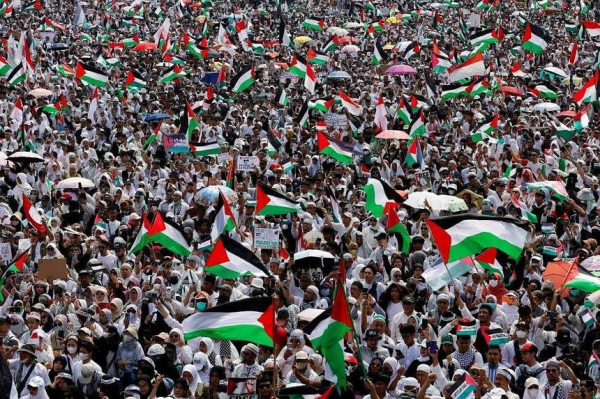 People waving Palestinian and Indonesian flags during a rally supporting at the National Monument complex in Jakarta on Nov 5. PHOTO: REUTERS