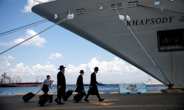 Ultra-orthodox Jews carry their belongings in Haifa, Israel, to a ship bound for Cyprus. Photograph: Shir Torem/Reuters
