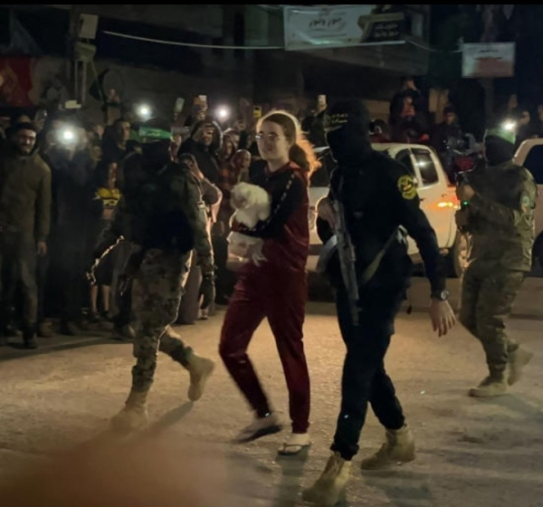 Hamas and Islamic Jihad fighters accompany a newly released Israeli hostage, held since the Hamas' October 7 attacks, before handing them over to the Red Cross in Rafah, in the southern Gaza Strip on November 28, 2023.Hamas released the fifth group of Israeli hostages on Tuesday including, a 17-year-old girl who was kidnapped with her family dog, Bella.