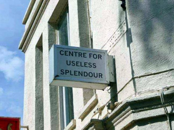 plain sign that says "centre for useless splendour" on the side of a building.