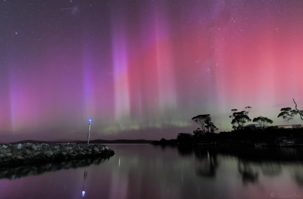 A later image in the aurora sequence, with 2 blue tinged columns at the left, one directly above the blue warning light. 2 strikingly brighter and larger width in the centre, and faded thinner columns to the right in shades of pastel red