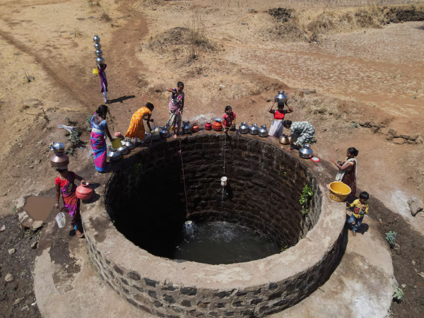 A drone view of women drawing water from a well on a hot day in Kasara, India, May 1, 2024.