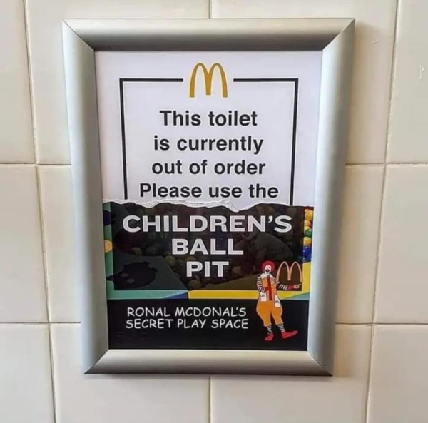 sign on wall with mcdonald's logo:
This toilet is currently out of order Please use [tear in sign revealing a sign underneath that says] Children's Ball Pit

Ronal McDonal's  [sic] Secret Play Space 