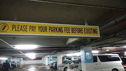 sign in a parking garage that says [sic]: Please pay your parking fee before existing