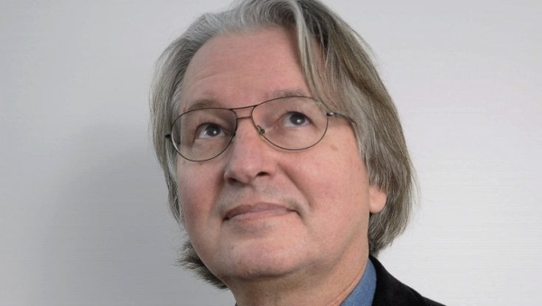 Bruce Sterling, wearing glasses and looking up