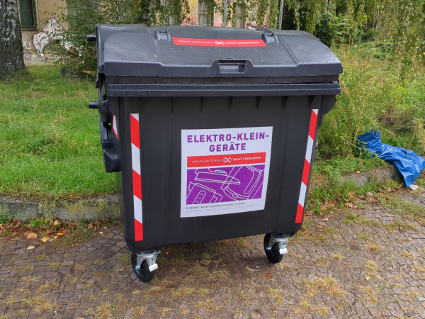 Big black bin with red and white "danger" tape on the sides. One should remove batteries before throwing in appliances.