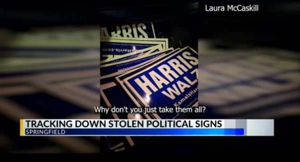 Capture of TV news broadcast playing a video that shows a car trunk full of stolen Harris/Walz yard signs 