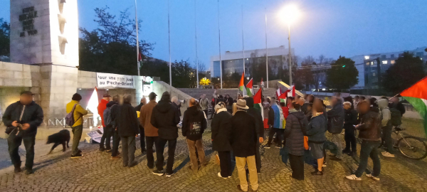 Le rassemblement au pied du monument au mort. On voit un groupe d'environ 100 personnes.