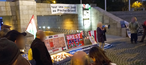 La tribune au pied du monument aux morts. Des bougies ont été déposées. Un panneau Brest avec Gaza décoré d'une guirlande, des drapeaux, une banderole Pour une paix juste au Proche orient.