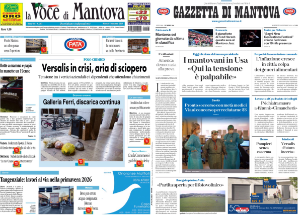 La foto mostra due prime pagine di giornali affiancate su uno schermo. A sinistra c'è "La Voce di Mantova" e a destra "Gazzetta di Mantova".   Nella prima pagina de "La Voce di Mantova", il titolo principale è "Versalis in crisi, aria di sciopero", con un sottotitolo che parla di tensioni tra i vertici aziendali e i dipendenti che attendono chiarimenti. Un altro titolo visibile è "Galleria Ferri, discarica continua".   Nella prima pagina della "Gazzetta di Mantova", il titolo principale è "I mantovani in Usa: 'Qui la tensione è palpabile'". Un altro titolo menziona l'influenza che cresce e il rischio collasso dei geriatri ambulatoriali.   Entrambe le pagine contengono vari altri articoli e immagini, ma i dettagli non sono completamente leggibili nella foto.  .