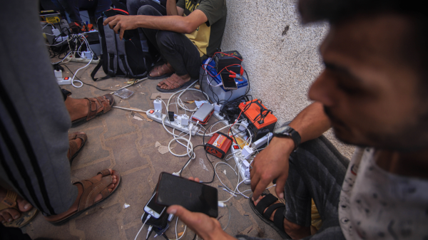 Palestinians charge mobile phones and batteries using portable charging stations on a street in western Khan Younis, Gaza, on Tuesday, Oct. 31, 2023. Photographer: Ahmad Salem/Bloomberg via Getty Images

