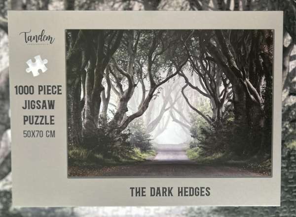 Box for the Dark Hedges 1000 piece jigsaw. Shows the image as described in the previous picture, on a light grey background. On the left it reads “Tandem. 1000 piece jigsaw puzzle.  50 x 70 cm