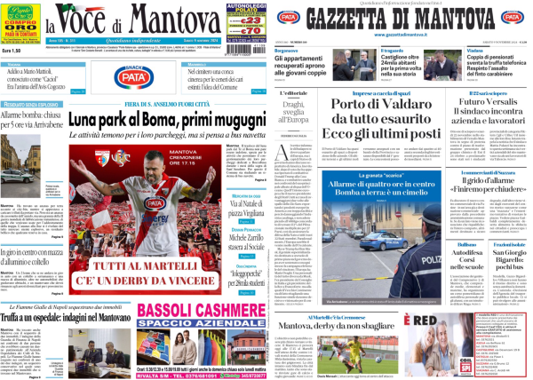 La foto mostra due pagine di giornale affiancate su uno schermo. A sinistra c'è "La Voce di Mantova" e a destra "Gazzetta di Mantova".   Nella prima pagina di "La Voce di Mantova", il titolo principale è "Luna park al Boma, primi mugugni". Sotto c'è una foto di un evento sportivo con il titolo "Tutti al Martelli c'è un derby da vincere".   Nella prima pagina della "Gazzetta di Mantova", il titolo principale è "Porto di Valdaro è tutto esaurito. Ecco gli ultimi posti". Ci sono anche altre notizie minori e una foto di un agente di polizia.  Entrambe le pagine contengono vari articoli e immagini, con pubblicità in basso.  .