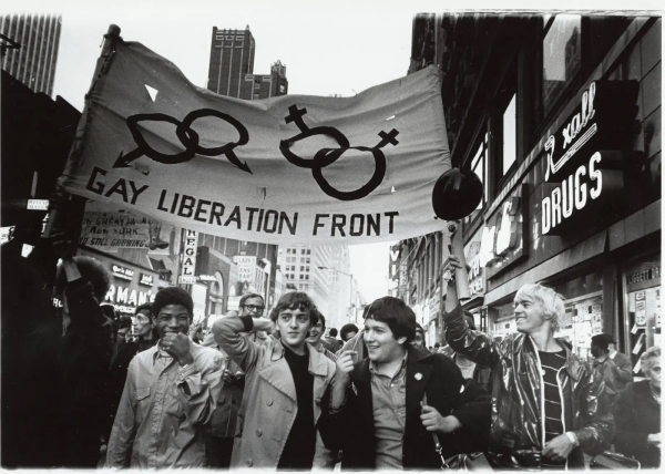 Black and white photo showing a group of men marching under a big Gay Liberation Front banner