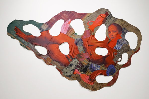 Hanging wall textile with round cut outs throughout, and an image of a reclining Black woman in orange tones