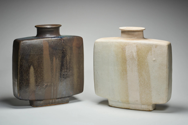 Two square-shaped ceramic vases with small bottle-like openings, one in cream and one in medium-brown shades