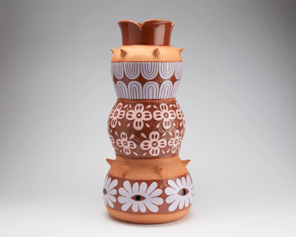 Tall multi-tiered vessel with floral and abstract patterns in orange, gray, and red-brown