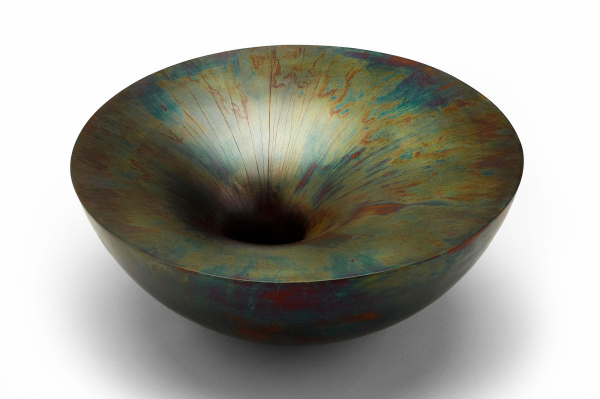 Smooth round bowl with a small central hole and a bronze-green patina over the surface