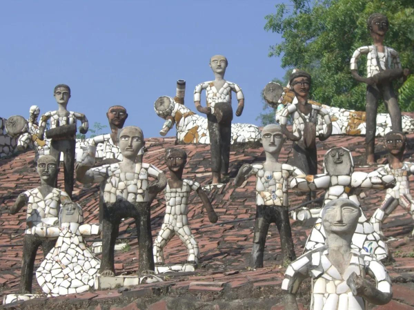 Figures made of white and gray stone, standing on a hill inlaid with red brick