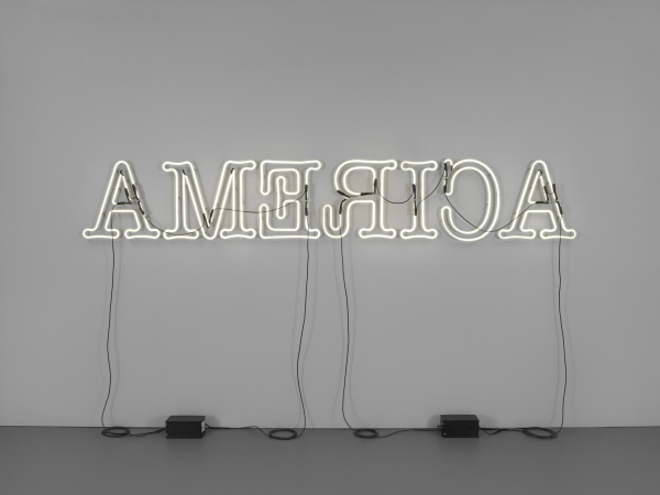 A white neon sign lit up with the text "AMERICA" but the E, R, and C are shown to be backwards