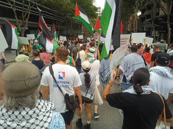 People marching with Palestinian flags and kuffiyeh