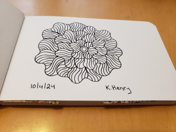 Hand drawn generative/procedural art in ink on an open page of my sketchbook. The abstract pattern is floral.