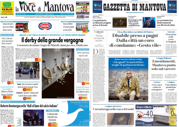 La foto mostra due prime pagine di giornali affiancate. A sinistra c'è "La Voce di Mantova" e a destra "Gazzetta di Mantova".   Nella prima pagina de "La Voce di Mantova", il titolo principale è "Il derby della grande vergogna", che riguarda un evento sportivo. Ci sono anche altre notizie e immagini, tra cui una foto di bagni pubblici e un articolo su Roberto Baggio.  Nella prima pagina della "Gazzetta di Mantova", il titolo principale è "Disabile preso a pugni. Dalla città un coro di condanne: 'Gesto vile'". Ci sono anche altre notizie, tra cui un articolo su una tartaruga in una vasca di sassi e un'immagine di una persona in uniforme mimetica.  Entrambe le pagine contengono vari annunci pubblicitari e altre notizie minori.  .