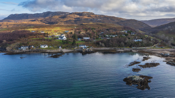 An aerial view of the small village of Ord on the Isle of Skye showing land, houses and Ord Bay. 