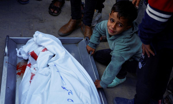 Un niño llora a su hermano en el hospital Nasser de Khan Younis. El chico murió al buscar internet en un café de Gaza que fue atacado por Israel, el 12 de noviembre de 2024. (Mohammed Salem / REUTERS)