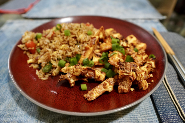 A photo of the final meal. There's stir fried rice, with vegetables and eggs. There are also pieces of cooked tofu, which were cooked on the waffle iron, then sliced into thin strips. 