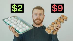 Man holding a cartoon of eggs in his left and right hands 
left $2 right $9 