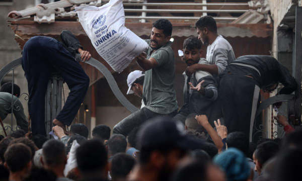 Palestinos de Gaza trepan a un camión con ayuda de Naciones Unidas en Deir Al-Balah, el 3 de noviembre de 2024. (Majdi Fathi / NurPhoto via Getty Images)