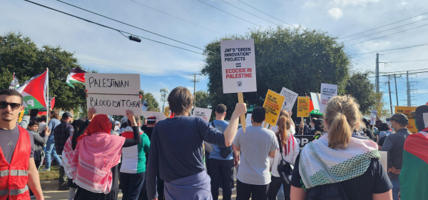 A sign held by a protester reads JNF Green Innovation Projects equal Ecocide. 