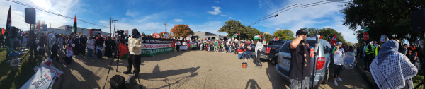 A long panorama of the protest with banners and signs condemning the genocide in Palestine. 