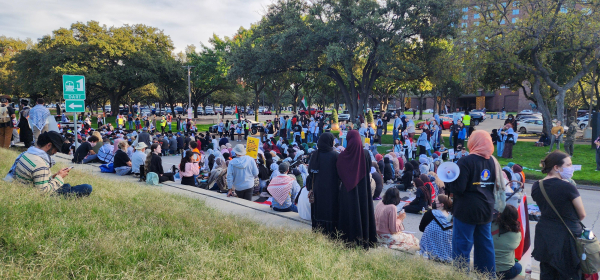 People in the street kneeling as a protest gathers around them.