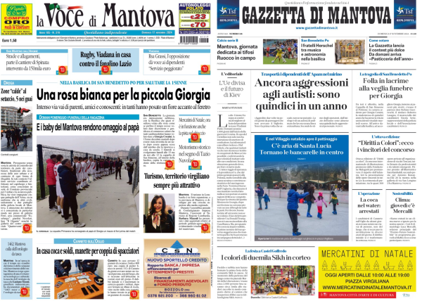 Nell'immagine ci sono due prime pagine di giornali affiancate. A sinistra c'è "La Voce di Mantova" e a destra "Gazzetta di Mantova".   La prima pagina de "La Voce di Mantova" ha come titolo principale "Una rosa bianca per la piccola Giorgia". Sotto il titolo ci sono alcune immagini, tra cui una di persone che camminano e un'altra di un'auto da corsa.   La prima pagina della "Gazzetta di Mantova" ha come titolo principale "Ancora aggressioni agli autistici: sono quindici in un anno". Anche qui ci sono diverse immagini, tra cui una di persone che giocano a calcio e un'altra di un evento con molte persone.   In basso a destra nella pagina della "Gazzetta di Mantova" c'è un annuncio per i mercatini di Natale.  .