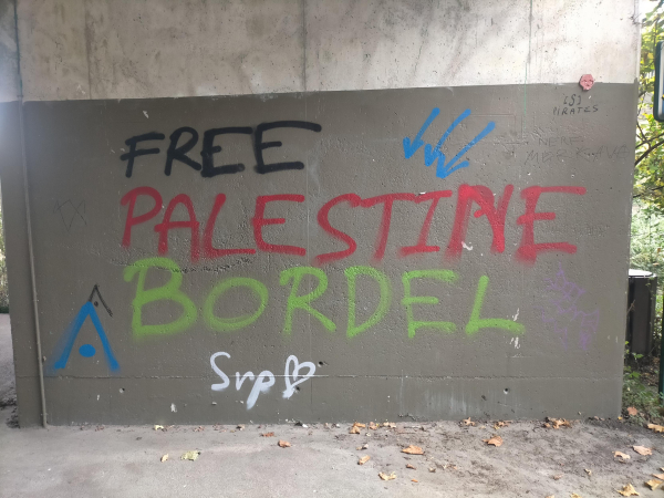 Un message écrit en gros et aux couleurs du drapeau palestinien sur le pilier d'un pont :
FREE
PALESTINE
BORDEL
(En petit : svp 🤍)