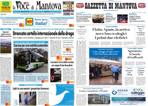 La foto mostra due pagine di giornali affiancate. A sinistra c'è "La Voce di Mantova" e a destra "Gazzetta di Mantova".   Nella prima pagina di "La Voce di Mantova", il titolo principale è "Stroncato cartello internazionale della droga", con un sottotitolo che menziona l'arresto di un uomo in Colombia e in Spagna per oltre 3 milioni di euro. Sotto, c'è un'immagine di un autobus con la didascalia "Due bus per una mobilità sostenibile".   Nella prima pagina della "Gazzetta di Mantova", il titolo principale è "Flotta Apam, in arrivo nove bus ecologici. I primi due elettrici". Sotto il titolo, c'è un'immagine di persone che camminano sotto la pioggia con ombrelli aperti.   Entrambe le pagine contengono vari articoli e immagini più piccole, ma i dettagli non sono facilmente leggibili dalla foto.  .