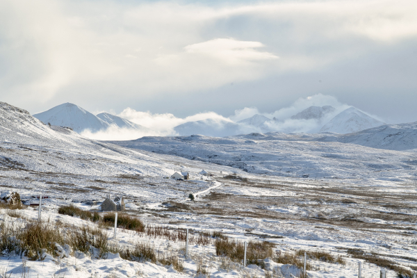 An image of snowy landscape and snow covered mountains in the distance. Isle of Skye, Scotland