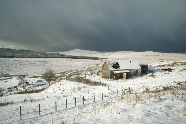 An image of a ruined house on a snowy moor with dark skies behind. Isle of Skye, Scotland