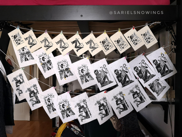 Picture of linoleum prints hung out to dry from some string