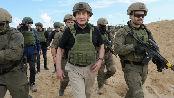 Benjamin Netanyahu, wearing military gear. walks with troops in Gaza 