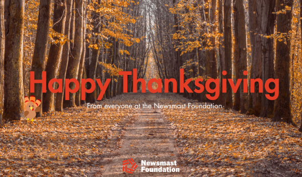 The background image is trees in autumn and a cartoon turkey can be seen. The text reads: Happy Thanksgiving from everyone at the Newsmast Foundation.