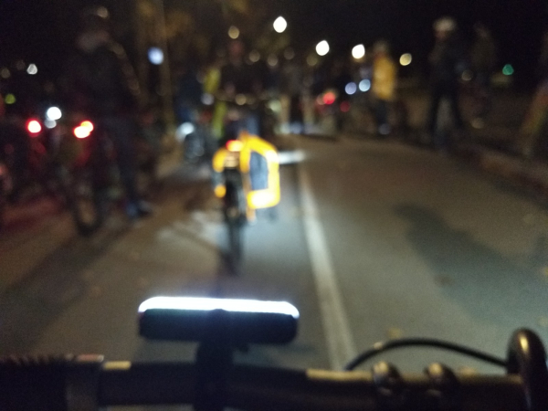 Deliberately out of focus photo of cyclists in the dark, with lights visible.