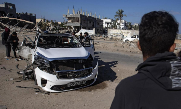 Los palestinos inspeccionan un vehículo destruido en la carretera Salah al-Din tras los ataques militares israelíes, al este de Khan Yunis, al sur de la Franja de Gaza. (EFE/EPA/HAITHAM IMAD)