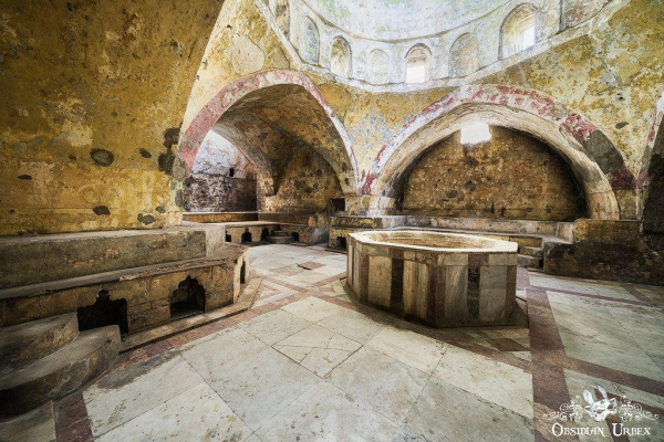 old bath house with pointed arched ceiling, bath is hexagonal in middle of room