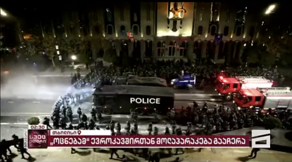 A huge column of riot police around water cannons clear the area of protestors in front of Georgian parliament.